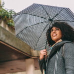 Lady smiling carrying an umbrella
