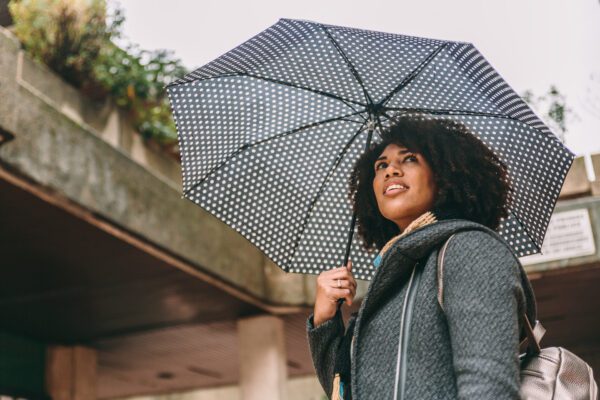 Lady smiling carrying an umbrella